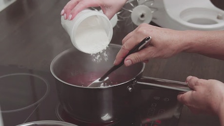 Pouring sugar into a pan