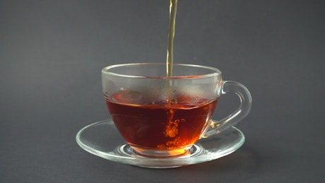 Pouring tea in a glass cup