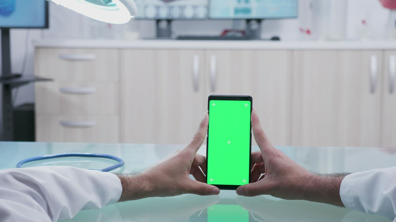 POV of a doctors hands looking at a cell phone - Free Stock Video
