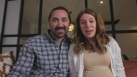 Pregnant couple talking on webcam