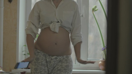 Pregnant woman dancing inside.