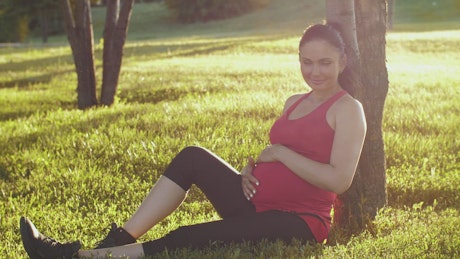 Pregnant woman sitting in a park