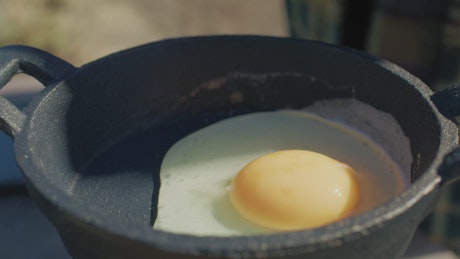 Preparing eggs at a campsite.
