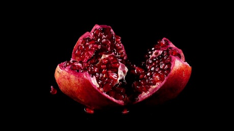 Presentation of a pomegranate on a black background.