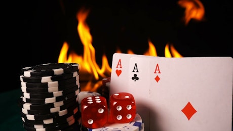 Presentation of cards, dice, chips with fire in the background.