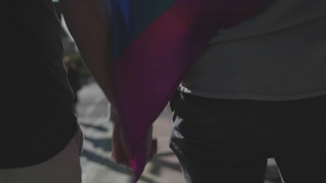 Pride LGBTQ couple walking in the street.