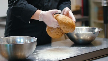 Professional chef preparing dough in a kitchen.