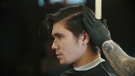 Profile of a man while having his hair cut.