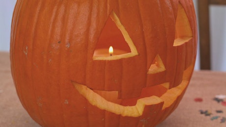 Pumpkin for halloween with a lit candle inside.