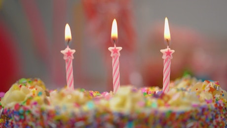Putting out candles on a colorful cake.