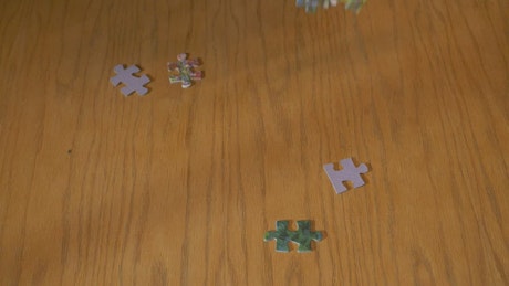 Puzzle pieces falling on a table
