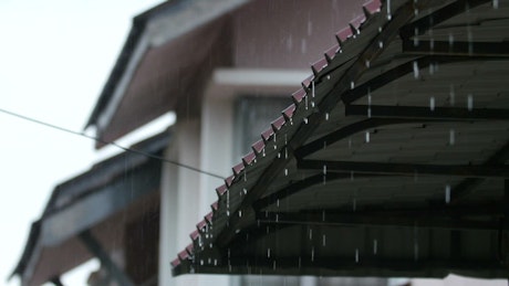 Rain falling off of a rooftop.
