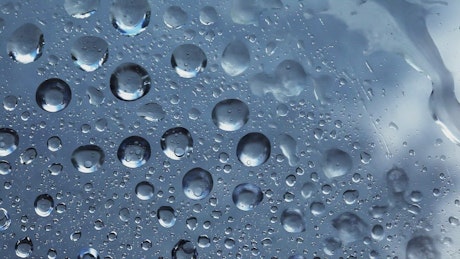 Rain water droplets moving on the glass