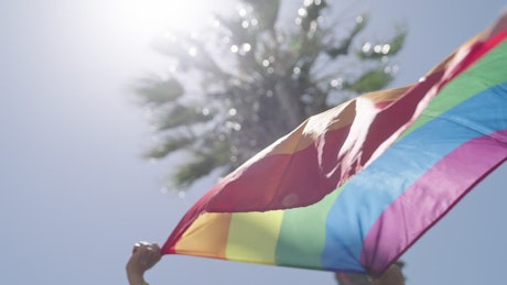 Rainbow flag waving during a pride parade.