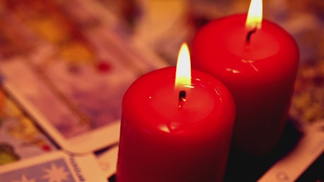 Red candles surrounded by tarot cards.