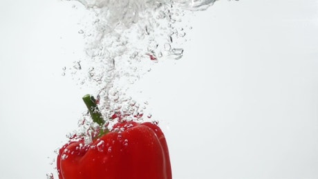 Red pepper falling through water