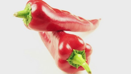 Red peppers rotating on white