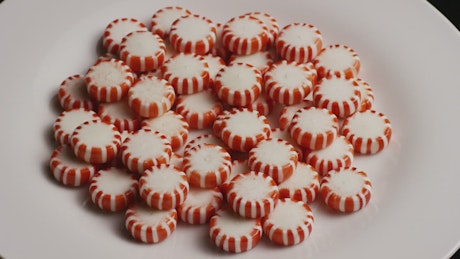 Red spermints on a white plate rotating