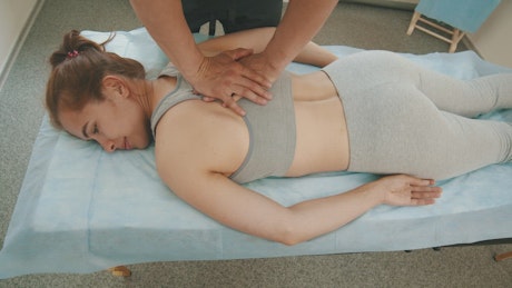 Relaxing massage on the back of a young woman