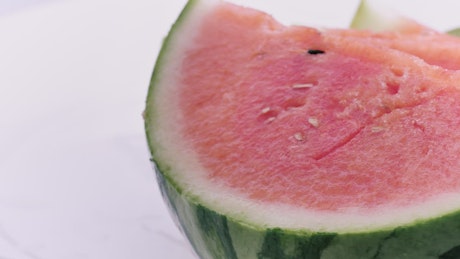 Rich watermelon cut into slices on a white background.