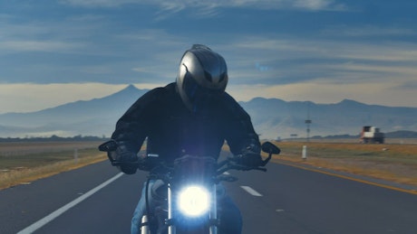 Riding a motorbike fast on a highway.