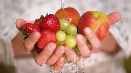 手牵着手清洗草莓、苹果和葡萄