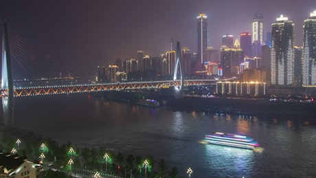 River with a bridge in Chongqing city at night.