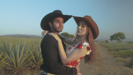 Romantic couple with Mexican style in a sunny field.