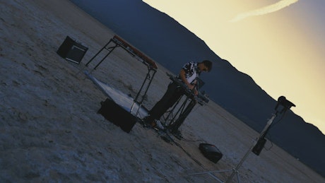 Rotating shot of a DJ playing in a lonely desert