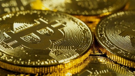 Rotating shot of shiny gold Bitcoin cryptocurrency.