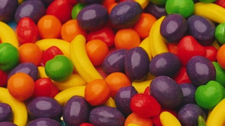 Rotating texture of many fruit-shaped candies.