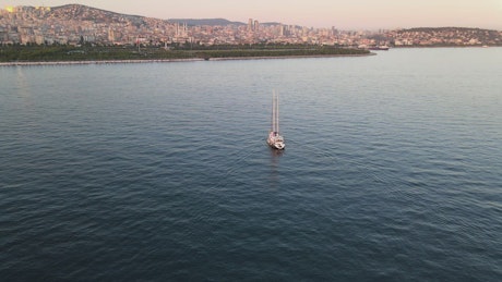 Sailboat sailing near the coast of a city