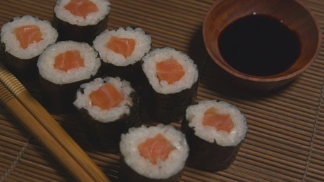 Salmon rolls by chopsticks.