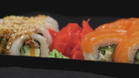 Salmon sushi rotating on a plastic tray