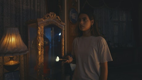 Scared young woman in a haunted house.