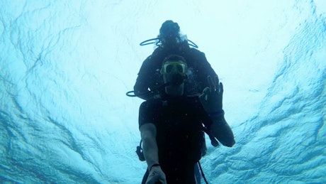 Scuba diver with instructor diving in the sea.