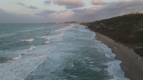 Sea waves covering a beach seen from above