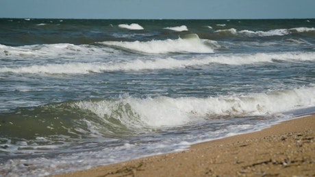 Sea waves reaching the beach sand.
