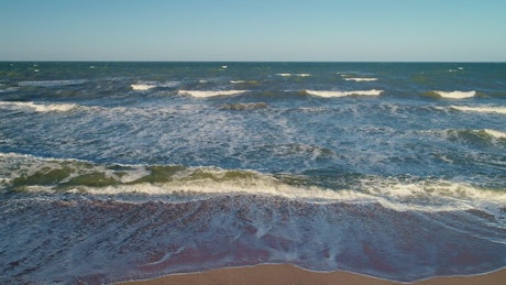 Sea waves reaching the sand on the beach.