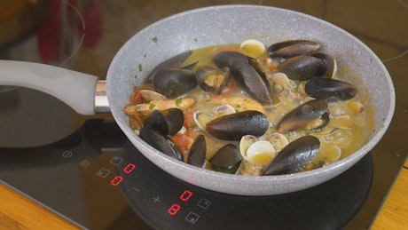 Seafood being boiled in a pan.