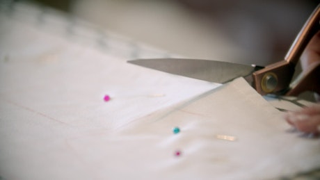 Seamstress cutting white fabric