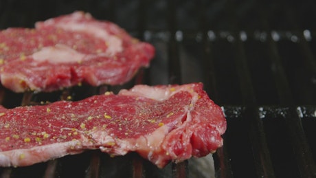 Seasoned steak on the grill.