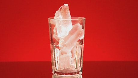 Served glass of soda on a red background.
