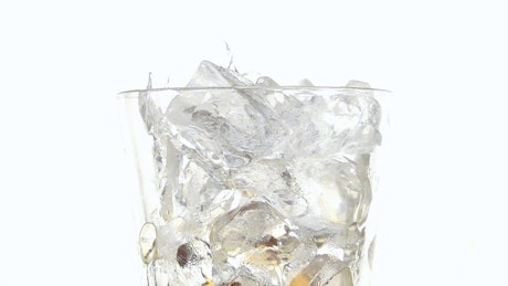 Serving soda in a glass with ice cubes on a white background.