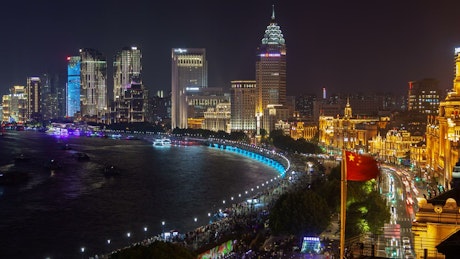 Shanghai river and city skyscrapers illuminated.