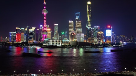 Shanghai river and illuminated city buildings.