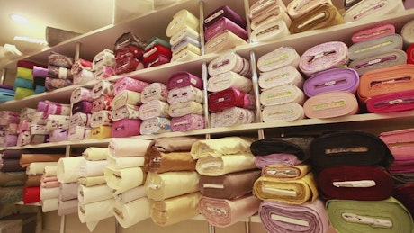 Shelf full of fabric rolls in a store.