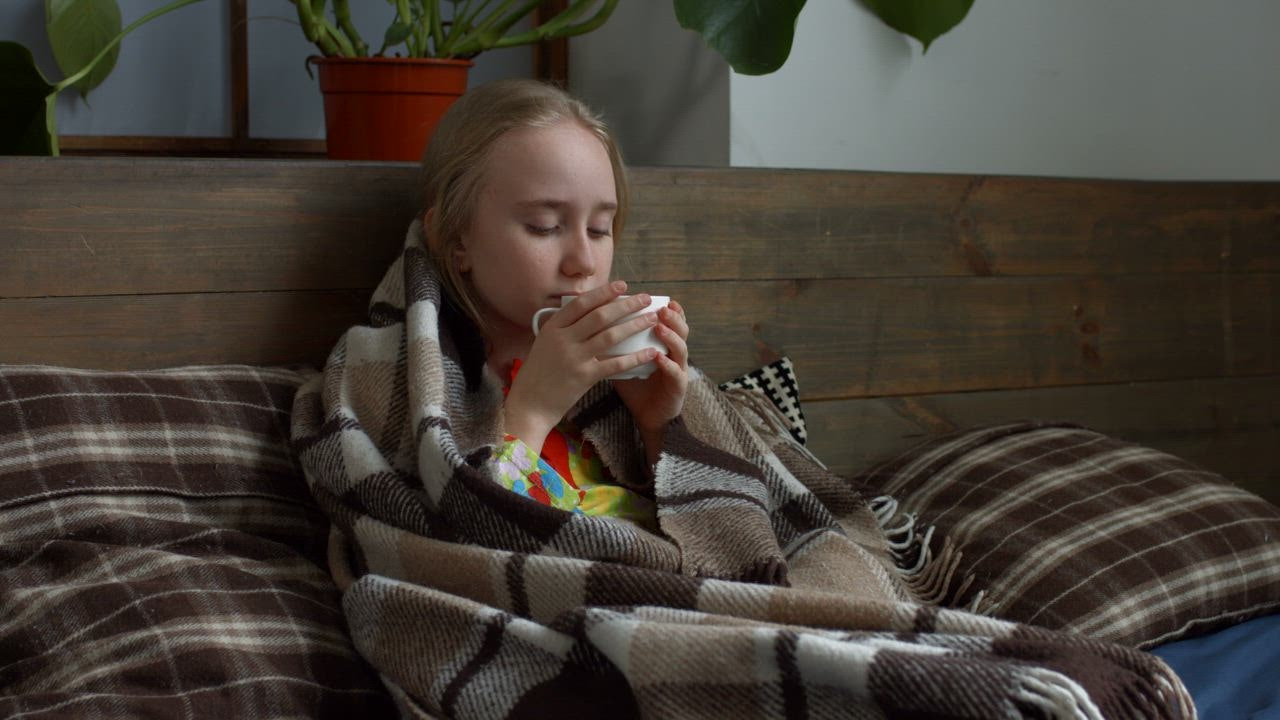 Sick girl sheltered while drinking a tea - Free Stock Video