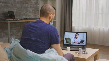Sick man in online video consultation with doctor