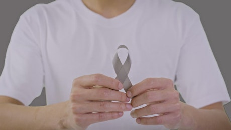 Sign of support against brain cancer with a gray ribbon.